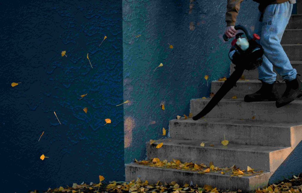 Person using a leaf blower on stairs