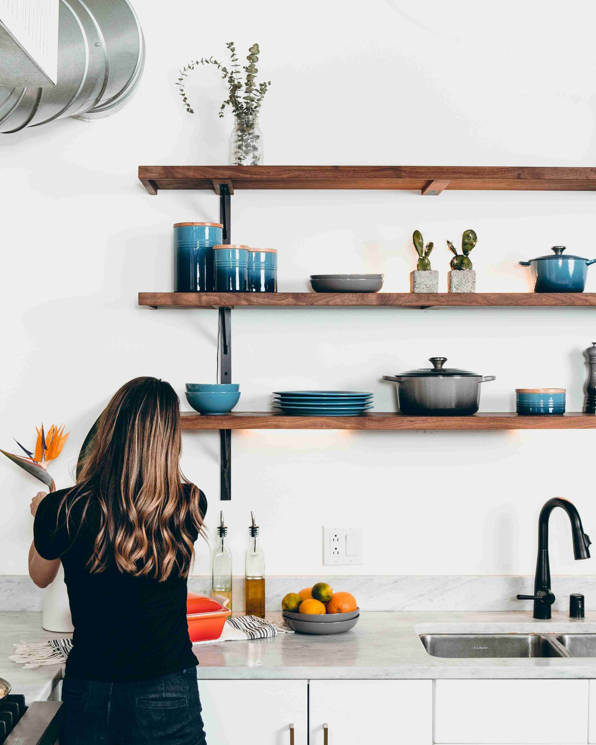 Woman cleaning kitchen counter by sink