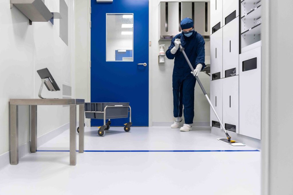 Person mopping a cleanroom floor meticulously